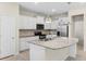 Modern kitchen features white cabinets, stainless steel appliances, and a granite island at 7247 Oakmoss Loop, Davenport, FL 33837