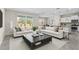 Stylish living room with a large sofa, elegant decor, and a seamless transition to the kitchen at 7247 Oakmoss Loop, Davenport, FL 33837