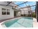 Backyard pool and patio with a screened enclosure and landscaped yard at 7247 Oakmoss Loop, Davenport, FL 33837