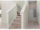 Carpeted staircase with white railing, leading to the upper floor at 7247 Oakmoss Loop, Davenport, FL 33837