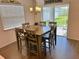 Bright dining room with modern chandelier, a rustic farmhouse sign, and sliding glass doors to the backyard at 737 Daphne Dr, Polk City, FL 33868