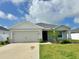 Charming single-story home features a manicured lawn, inviting curb appeal, and a neutral color palette at 737 Daphne Dr, Polk City, FL 33868