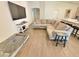 Comfortable living room with L-shaped couch, television and laminate flooring makes relaxing and entertaining easy at 737 Daphne Dr, Polk City, FL 33868