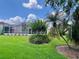 A screen enclosed patio with a manicured lawn and mature landscaping in the backyard at 741 Canberra Rd, Winter Haven, FL 33884