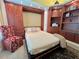 Bedroom featuring Murphy bed, custom built-in shelves, and a red patterned chair at 741 Canberra Rd, Winter Haven, FL 33884