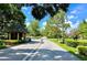 Community entrance with a guard house, security gate, and lush landscaping on either side of the road at 741 Canberra Rd, Winter Haven, FL 33884