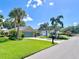 Charming home with well-manicured lawn, tropical palm trees, and a paver driveway at 741 Canberra Rd, Winter Haven, FL 33884
