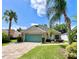 Charming single-story home with a well-maintained lawn, lush landscaping, and a brick-paved driveway at 741 Canberra Rd, Winter Haven, FL 33884