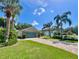 Well-manicured front lawn and tropical landscaping compliment this single-story residence at 741 Canberra Rd, Winter Haven, FL 33884