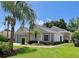 Beautifully landscaped single-story home featuring tropical palm trees at 741 Canberra Rd, Winter Haven, FL 33884