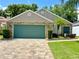 Single-story home featuring a stone accent wall and two-car garage at 741 Canberra Rd, Winter Haven, FL 33884