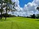 Beautiful view of a meticulously maintained golf course with rolling hills, mature trees, and a clear sky at 741 Canberra Rd, Winter Haven, FL 33884