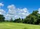 Picturesque golf course featuring manicured greens, a paved path, and a backdrop of lush green trees at 741 Canberra Rd, Winter Haven, FL 33884