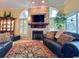 Cozy living room with stacked stone fireplace, arched windows, and plush seating at 741 Canberra Rd, Winter Haven, FL 33884