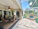 Screened in patio with ceiling fans, seating, brick pillars, and a water feature at 741 Canberra Rd, Winter Haven, FL 33884