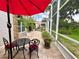 A brick accented screened-in patio with a water feature and potted plants connects to an outdoor dining area at 741 Canberra Rd, Winter Haven, FL 33884