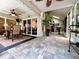 A dining table and chairs sits on a covered patio outside sliding glass doors and near a screened-in patio at 741 Canberra Rd, Winter Haven, FL 33884