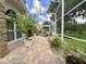 A brick accented screened-in patio features a water feature, seating, and potted plants at 741 Canberra Rd, Winter Haven, FL 33884