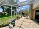 A screened-in patio features brick accents, potted plants and access to an outdoor dining area at 741 Canberra Rd, Winter Haven, FL 33884