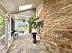 A view of the screened-in patio with brick accents, potted plants and a view of the pool area at 741 Canberra Rd, Winter Haven, FL 33884