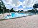 Large outdoor community pool with shallow end and plenty of lounge chairs, surrounded by mature trees at 741 Canberra Rd, Winter Haven, FL 33884