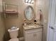 Powder room featuring a granite vanity, oval mirror, and a neutral color palette at 741 Canberra Rd, Winter Haven, FL 33884