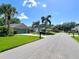 Street view of a home with lush landscaping, a well-manicured lawn, and mature trees at 741 Canberra Rd, Winter Haven, FL 33884