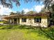 Side view of a cozy single-Gathering home with a green lawn, enhancing its peaceful suburban setting at 8110 Walt Williams Rd, Lakeland, FL 33809