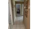 Inviting hallway with tile flooring, leading to a bedroom with a comfortable bed at 8110 Walt Williams Rd, Lakeland, FL 33809