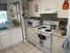 Well-lit kitchen featuring white cabinetry, tile flooring, and modern appliances for a cozy cooking space at 8110 Walt Williams Rd, Lakeland, FL 33809