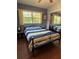 Bedroom with a mirror closet, hardwood floors, a ceiling fan and natural light from the window at 816 Casselberry Dr, Lake Wales, FL 33853