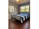 Bright bedroom with hardwood floors, two windows and a ceiling fan at 816 Casselberry Dr, Lake Wales, FL 33853