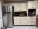 Well-equipped kitchen featuring stainless steel refrigerator and built-in microwave, next to cream-colored cabinets at 816 Casselberry Dr, Lake Wales, FL 33853