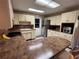 Charming kitchen featuring cream cabinets, brick backsplash, and stainless-steel appliances at 816 Casselberry Dr, Lake Wales, FL 33853