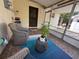 Relaxing screened porch features wicker chairs, blue accents, and an outdoor grill for leisure at 816 Casselberry Dr, Lake Wales, FL 33853
