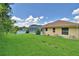 Home exterior showcasing a lush green lawn and a screened-in pool area at 10708 Belo Horizonte Ave, Clermont, FL 34711