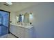 Bathroom features a double vanity with marble countertops and decorative mirrors and light fixtures at 10708 Belo Horizonte Ave, Clermont, FL 34711