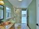Stylish bathroom featuring a mosaic-tiled shower, a copper sink, and access to the pool at 10708 Belo Horizonte Ave, Clermont, FL 34711