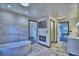 Relaxing bathroom with a freestanding tub, a modern fireplace, and a large walk-in closet at 10708 Belo Horizonte Ave, Clermont, FL 34711