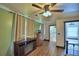 Cozy bedroom featuring a ceiling fan, wood floors, a fireplace, and neutral colored curtains at 10708 Belo Horizonte Ave, Clermont, FL 34711