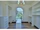 Walk-in closet with custom organizers, a large arched window, and laminate floors at 10708 Belo Horizonte Ave, Clermont, FL 34711