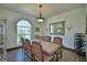 Spacious dining room featuring a traditional chandelier, large window, and stylish hardwood floors at 10708 Belo Horizonte Ave, Clermont, FL 34711