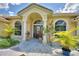 Inviting front entrance featuring arched windows and lush landscaping at 10708 Belo Horizonte Ave, Clermont, FL 34711