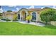 Lovely one-story home featuring arched windows and a manicured lawn at 10708 Belo Horizonte Ave, Clermont, FL 34711