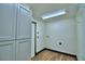 Clean laundry room with wood look flooring and white cabinets for optimal storage at 10708 Belo Horizonte Ave, Clermont, FL 34711