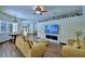 Spacious living room with modern fireplace, large-screen TV, and stylish couches at 10708 Belo Horizonte Ave, Clermont, FL 34711