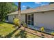 The back exterior of the home has a screened door and flower beds at 1100 Lowry Ave # 63, Lakeland, FL 33801