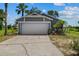 A single-story grey home, with a two-car garage and mature landscaping at 1100 Lowry Ave # 63, Lakeland, FL 33801