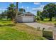 A single-story grey home, with a two-car garage and mature landscaping at 1100 Lowry Ave # 63, Lakeland, FL 33801