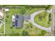 Aerial view of the property showcasing the home, driveway, landscaping, and solar panels at 1125 Rolling Woods Ln, Lakeland, FL 33813